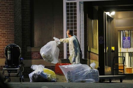 A man collects and bags items near the ambulance used to transport a patient with possible Ebola symptoms to Beth Israel Deaconess Medical Center in Boston, Massachusetts October 12, 2014. REUTERS/Brian Snyder