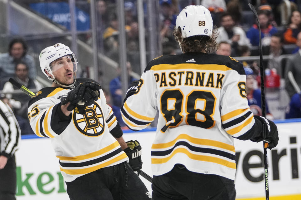 Boston Bruins' Brad Marchand (63) celebrates with David Pastrnak (88) after scoring a goal during the third period of an NHL hockey game against the New York Islanders Wednesday, Jan. 18, 2023, in Elmont, N.Y. The Bruins won 4-1. (AP Photo/Frank Franklin II)