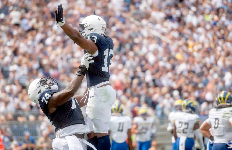 Penn State offensive lineman Olumuyiwa Fashanu lifts up running back Kaytron Allen to celebrate a touchdown during the game on Saturday, Sept. 9, 2023.