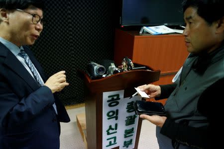 Moon Seoung-ok, president of the Headquarters of Reporting for Public Good, talks with his student in front of camcorders and spycams after a class in Seoul, South Korea, September 30, 2016. REUTERS/Kim Hong-Ji