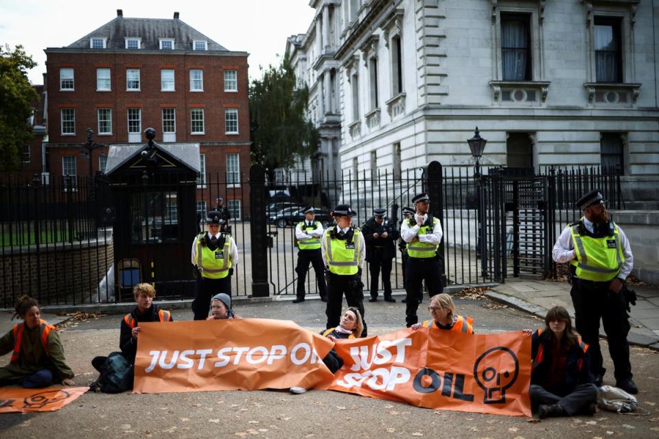 Members of the police stand near activists from Just Stop Oil near Downing Street (REUTERS)