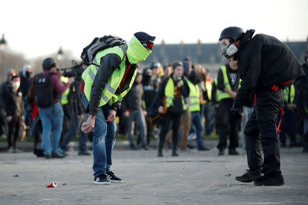 Protesters wearing yellow vests clash with French riot police near the Invalides during a demonstration of the "yellow vests" movement in Paris, France, February 16, 2019. REUTERS/Benoit Tessier