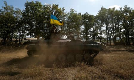 A Ukrainian armoured vehicle drives on a field near the eastern Ukrainian town of Pervomaysk, September 17, 2014. REUTERS/David Mdzinarishvili