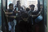 Refugees and migrants struggle to board a bus following their arrival by the Eleftherios Venizelos passenger ferry with over 2,500 migrants and refugees from the island of Lesbos at the port of Piraeus, near Athens, Greece, October 8, 2015. REUTERS/Yannis Behrakis