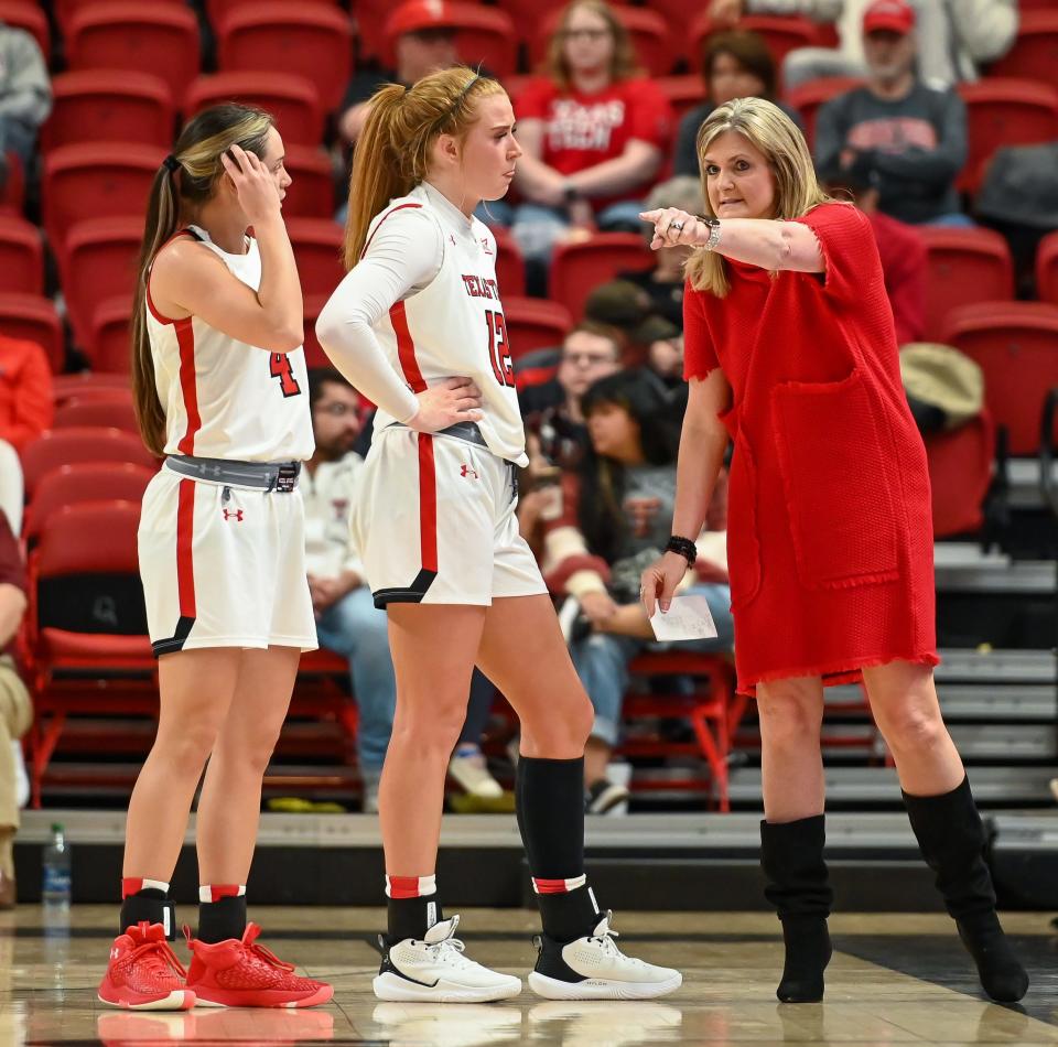 Texas Tech's head coach Krista Gerlich talks to her players Vivian Gray (12) and Lexy Hightower (4) at the game on Saturday, Jan. 8, 2022, at United Supermarkets Arena in Lubbock, Texas.