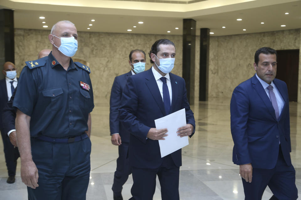 In this photo released by Lebanon's official government photographer Dalati Nohra, Lebanese Prime Minister-Designate Saad Hariri, center, arrives to his meeting with Lebanese President Michel Aoun at the presidential palace, in Baabda, east of Beirut, Lebanon, Wednesday, July 14, 2021. (Dalati Nohra/Lebanese Official Government via AP