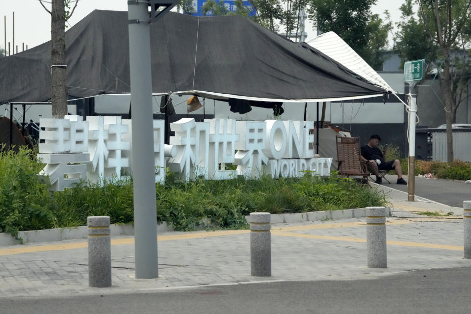 A homeowner camps near the sign for Country Garden One World City project under construction on the outskirts of Beijing, Thursday, Aug. 17, 2023. China's government is trying to reassure jittery homebuyers after the major real estate developer missed a payment on its multibillion-dollar debt, reviving fears about the industry's shaky finances and their impact on the struggling Chinese economy. (AP Photo/Ng Han Guan)