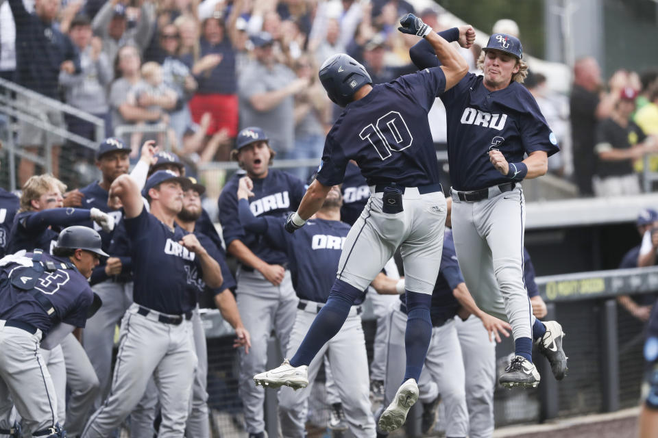Oral Roberts' Matt Hogan (10) celebrates after his three-run home run with Dylan Wipperman (2) during the third inning of an NCAA college baseball tournament super regional game against Oregon, Friday, June 9, 2023, in Eugene, Ore. (AP Photo/Amanda Loman)