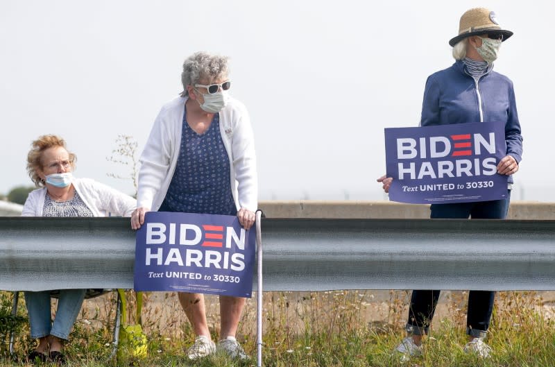 Vicki Smith, middle, and Karen DeMerit, right, wait for Democratic presidential candidate Joe Biden's arrival on Monday, Sept.