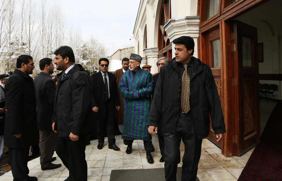 Afghan President Hamid Karzai, center, leaves after attending the funeral procession of Afghanistan's influential Vice President Mohammad Qasim Fahim in Kabul, Afghanistan, Tuesday, March 11, 2014. Fahim, a leading commander in the alliance that fought the Taliban who was later accused with other warlords of targeting civilian areas during the country's civil war, died on Sunday, March 9, 2014. He was 57. (AP Photo/Rahmat Gul)