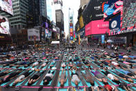 <p>People take part in the 15th annual Times Square yoga event celebrating the Summer Solstice, the longest day of the year, during classes in the middle of Times Square on June 21, 2017 in New York. (Photo: Timothy A. Clary/AFP/Getty Images) </p>