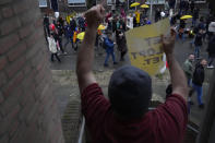 A resident clenches ahis fist while holding a sign reading "It's Not Right" as thousand of demonstrators march in Utrecht, Netherlands, Saturday, Dec. 4, 2021, to protest against COVID-19 restrictions and the lockdown. (AP Photo/Peter Dejong)