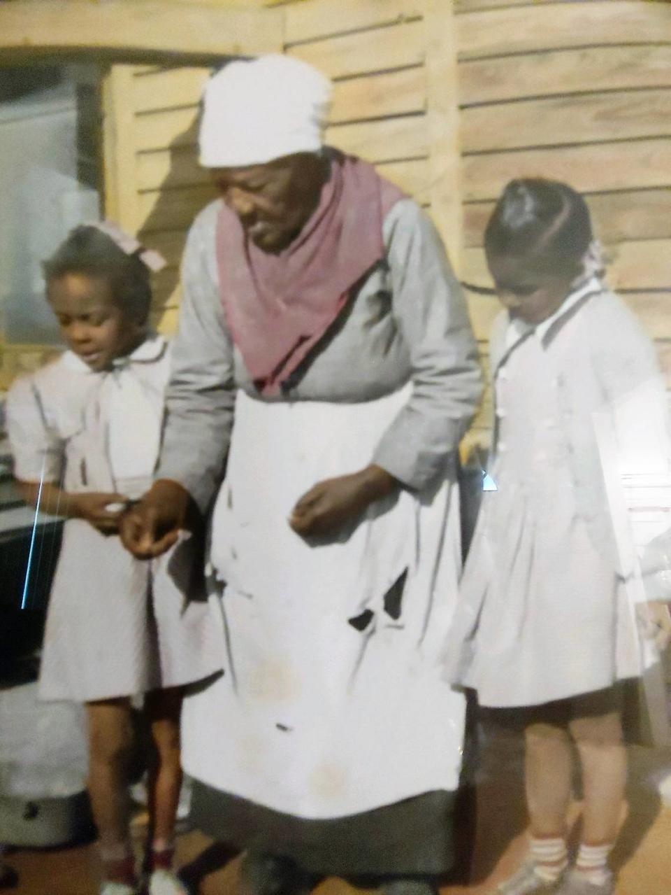 A family photograph shows cousins Dolores Clark and Georgia Bradsher with their great-grandmother Nellie Strayhorn, who had been enslaved.