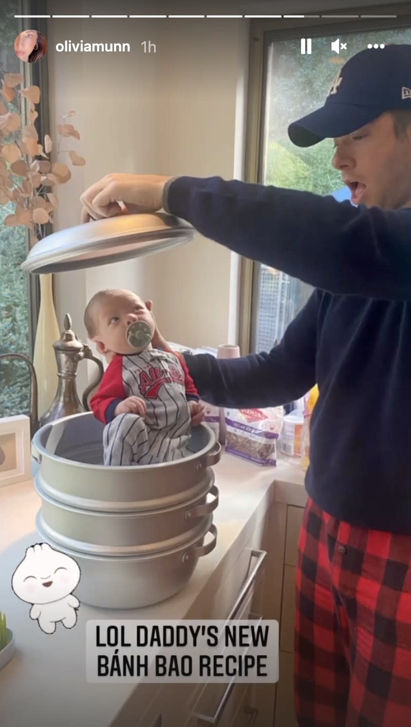 John holds a baby on top of a metal pot and hold the top above the baby's head