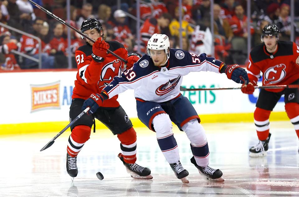 Columbus Blue Jackets right wing Yegor Chinakhov (59) battles New Jersey Devils center Dawson Mercer (91) for the puck during the second period of an NHL hockey game Wednesday Dec. 27, 2023, in Newark, N.J. (AP Photo/Noah K. Murray)