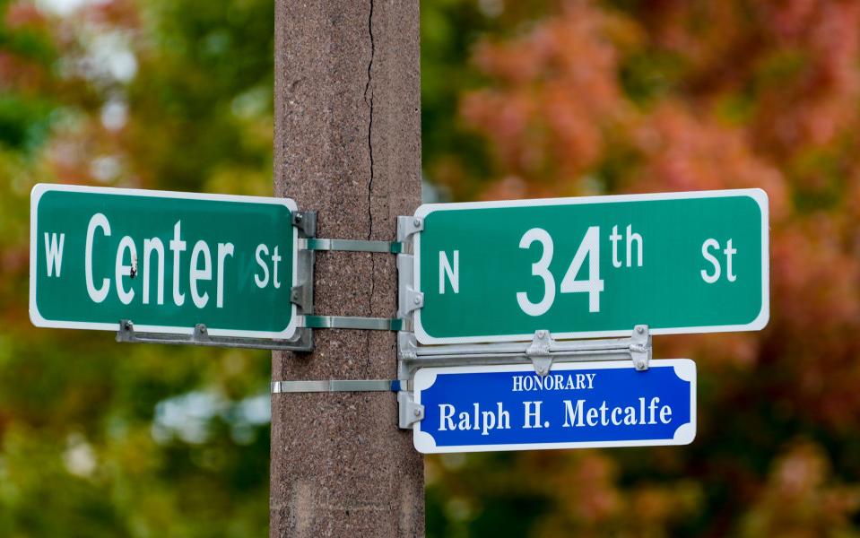 Fall foliage is seen in the background as 34th Street is renamed in honor of Olympic athlete, U.S. representative and scholar Ralph Metcalfe on Saturday at 3401 W. Center St. in Milwaukee.