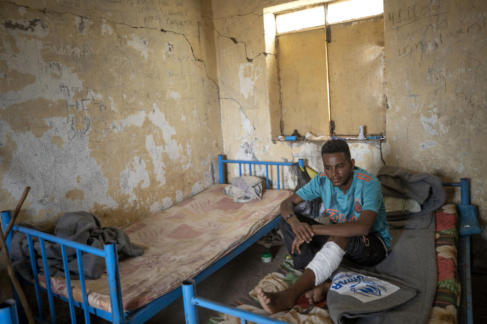 Hiwet Aregawi, 24, a Tigrayan who was allegedly attacked by the 'Fano' militia, young Amhara militias, rests his wounded leg in a shelter at the Hamdeyat Transition Center near the Sudan-Ethiopia border, eastern Sudan, Tuesday, Dec. 15, 2020. No one knows how many thousands of people have been killed in Tigray since the fighting began on Nov. 4, but the United Nations has noted reports of artillery strikes on populated areas, civilians targeted and widespread looting. (AP Photo/Nariman El-Mofty)