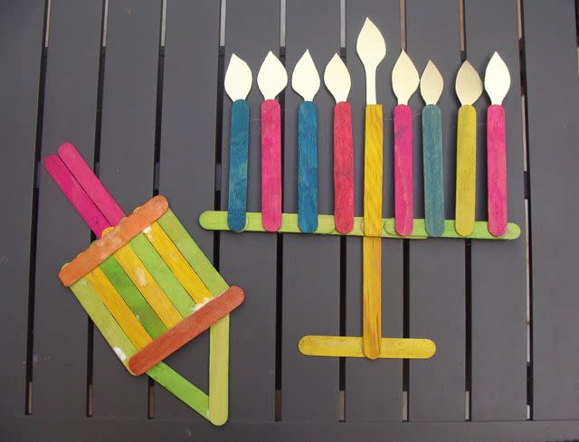 <p>Popsicle sticks and glue are all you need to whip up a batch of menorahs and dreidels for your Hanukkah decor. Use white glue — with some patience — or help out kids with a hot glue gun for faster results.</p><p><a href="https://www.creativejewishmom.com/2009/11/make-cute-chanukah-decorations-from-popsicle-sticks.html" rel="nofollow noopener" target="_blank" data-ylk="slk:Get the tutorial at Creative Jewish Mom;elm:context_link;itc:0;sec:content-canvas" class="link "><em>Get the tutorial at Creative Jewish Mom</em></a></p>