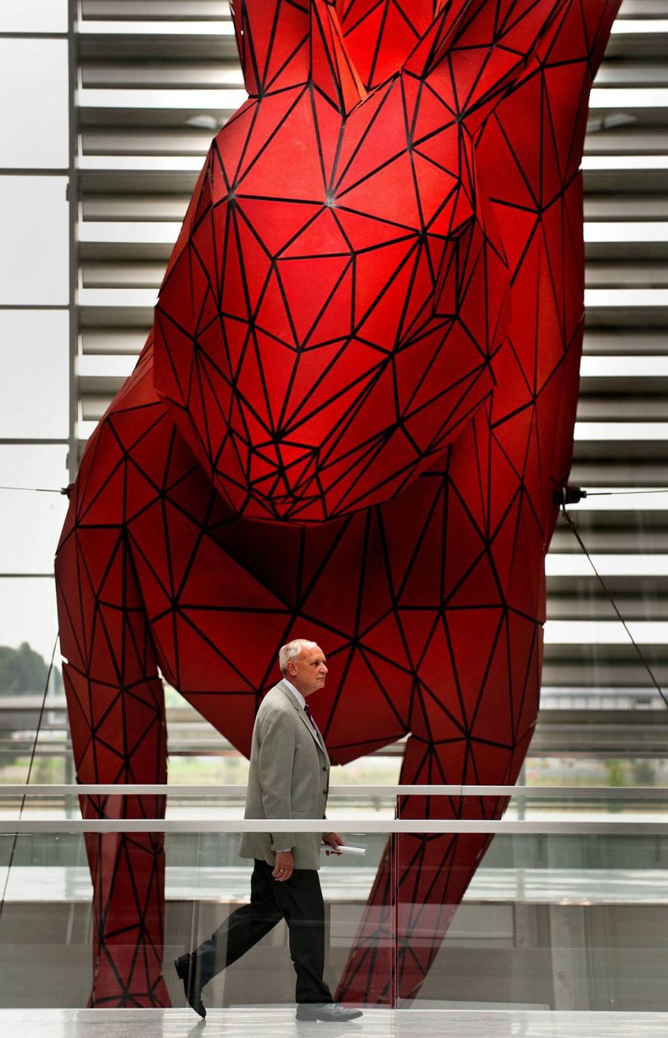 Hardy Acree, Sacramento County airports director, passes artist Lawrence Argent’s “Red Rabbit” sculpture, which seems to have leaped into the building from the fields outside.