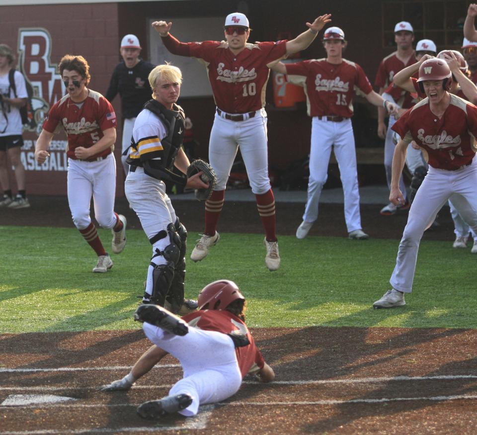 Bishop Watterson players celebrate Brandon Trout scoring the winning run before Watkins Memorial's Andrew Botts can get back to the plate after catching a wide throw on Tuesday.