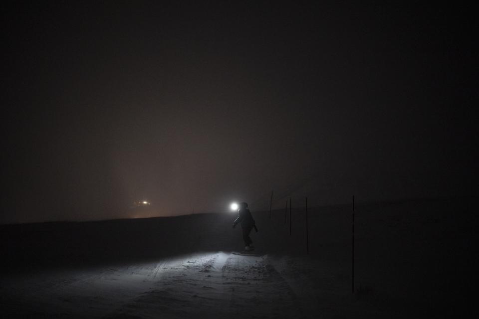 The Rev. Siv Limstrand walks with her rifle to the church's cabin in Bolterdalen, Norway, Monday, Jan. 9, 2023. For the lone pastor in this fragile, starkly beautiful environment, the challenge is to fulfill the church's historical mission of ministering to those in crisis while addressing a pressing and divisive contemporary challenge. "We pray every Sunday for everyone who's affected by climate change," Limstrand said. (AP Photo/Daniel Cole)