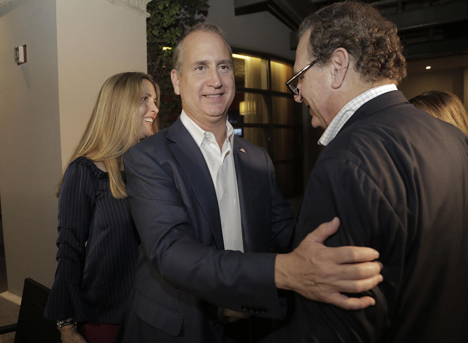 Congressman Mario Diaz-Balart, center, is greeted by his brother Lincoln Diaz-Balart as his wife, Tia, left, also greets supporters during a victory party at the Flamingo Terrace at Hialeah Park, Tuesday, Nov. 6, 2018, in Hialeah, Fla. (Jose A. Iglesias/Miami Herald via AP)