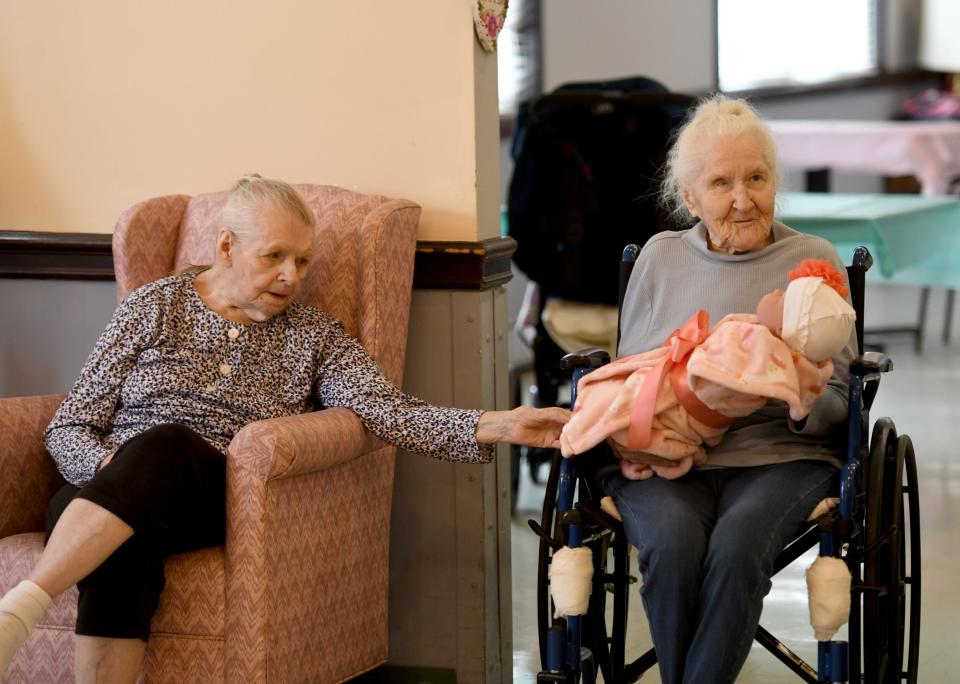 Residents Mary Ritchea, left, and Elaine Yanosik visit with a doll at Glenwood Care and Rehabilitation. The Canton facility hosted a "baby shower" for its memory-care residents who received life-like dolls and stuffed dogs donated by Pearl's Memory Babies.