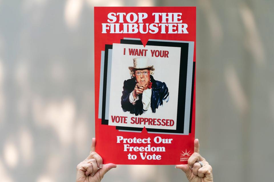 Virginia Shadron, of Atlanta, holds an anti-filibuster sign with the face of Senate Minority Leader Mitch McConnell of R-Ky., on it, during a rally in support of voting rights, Tuesday, Sept. 14, 2021, on Capitol Hill in Washington.