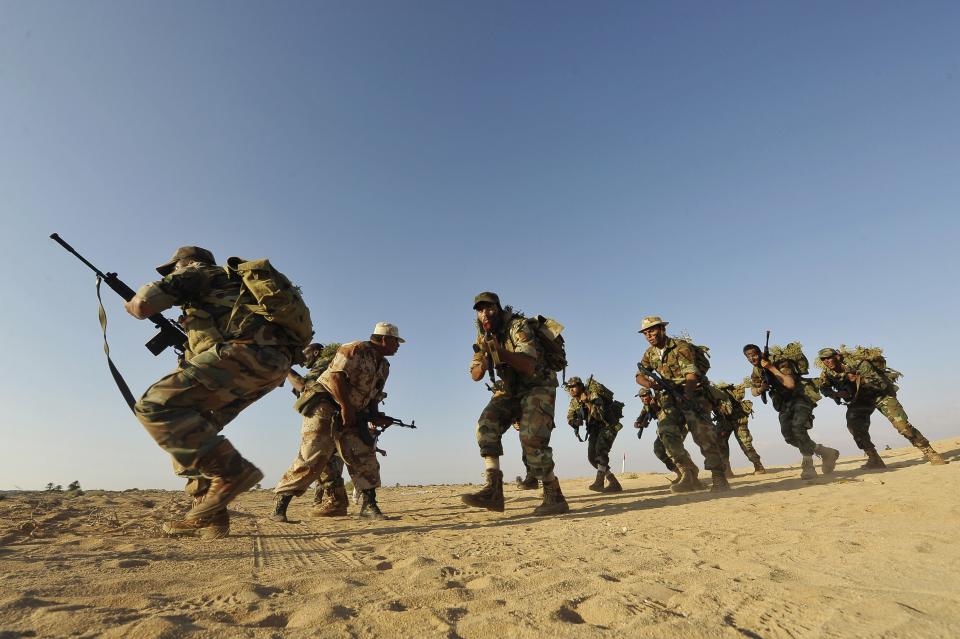 Trainee soldiers from the Libyan army execute combat manoeuvres during their graduation exam in Geminis