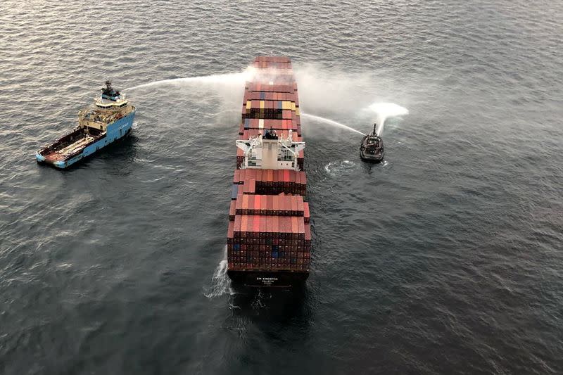 Tugboats pour water on the container ship Zim Kingston after it caught fire the day before off the coast of Victoria
