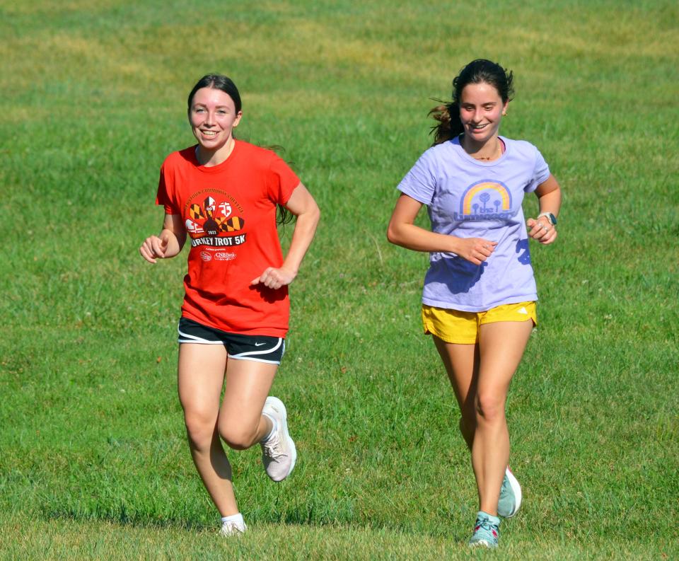 Smithsburg runners Kayla Hawbecker, left, and Ella Fisher are all smiles during the first day of cross country practice.
