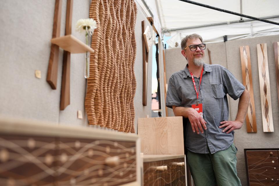 Steve Uren, of Grand Rapids, Wis., stands in his booth filled with his woodwork creations during Artisphere on Friday, May 10, 2024.