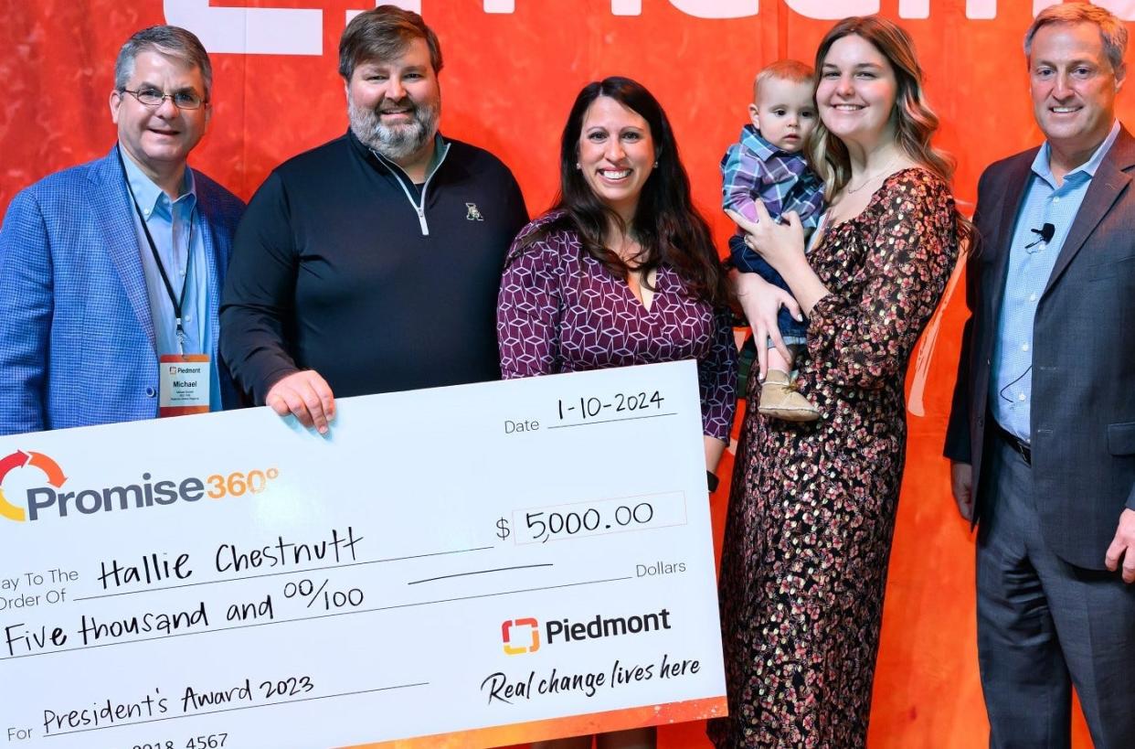 Hallie Chestnutt, a patient care tech at Piedmont Athens Regional, in January 2024 was awarded $5,000 after she was honored for saving the live of a newborn a year prior at the hospital. In the photo is (left to right) Michael Burnett, CEO of Piedmont Athens Regional; Will Stewart, Lorraine Stewart, Court Stewart, Hallie Chestnutt (holding Court) and Piedmont Healthcare President and CEO Kevin Brown.