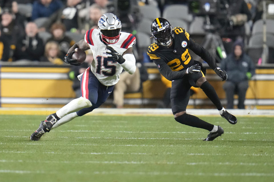 New England Patriots running back Ezekiel Elliott (15) runs with the ball past Pittsburgh Steelers cornerback Levi Wallace (29) during the first half of an NFL football game on Thursday, Dec. 7, 2023, in Pittsburgh. (AP Photo/Gene J. Puskar)