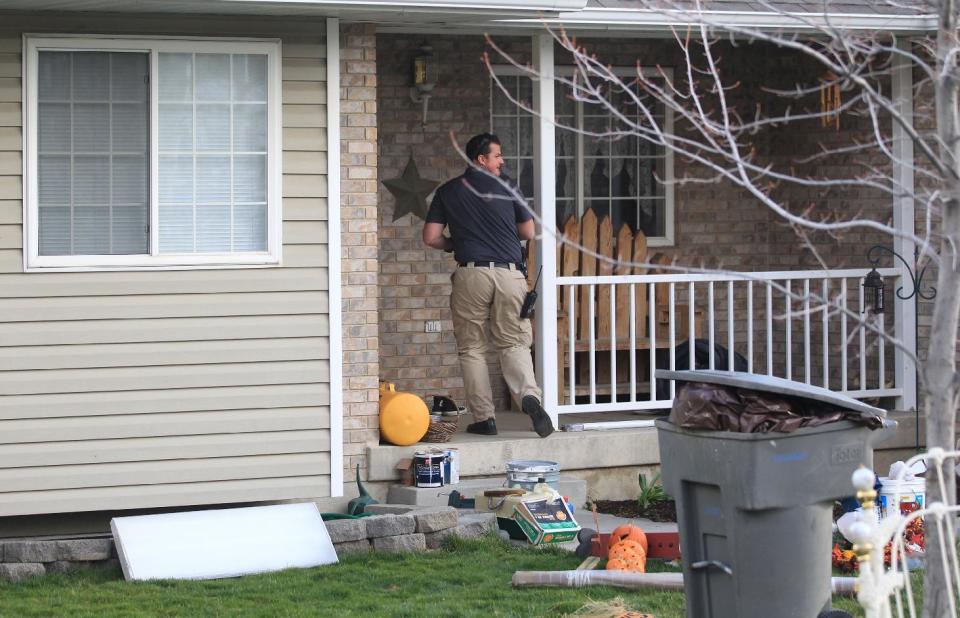 Pleasant Grove Police investigate the scene where seven infant bodies were discovered and packaged in separate containers at a home in Pleasant Grove, Utah, Sunday, April 13, 2014. According to the Pleasant Grove Police Department, seven dead infants were found in the former home of Megan Huntsman, 39. Huntsman was booked into jail on six counts of murder. (AP Photo/Rick Bowmer)