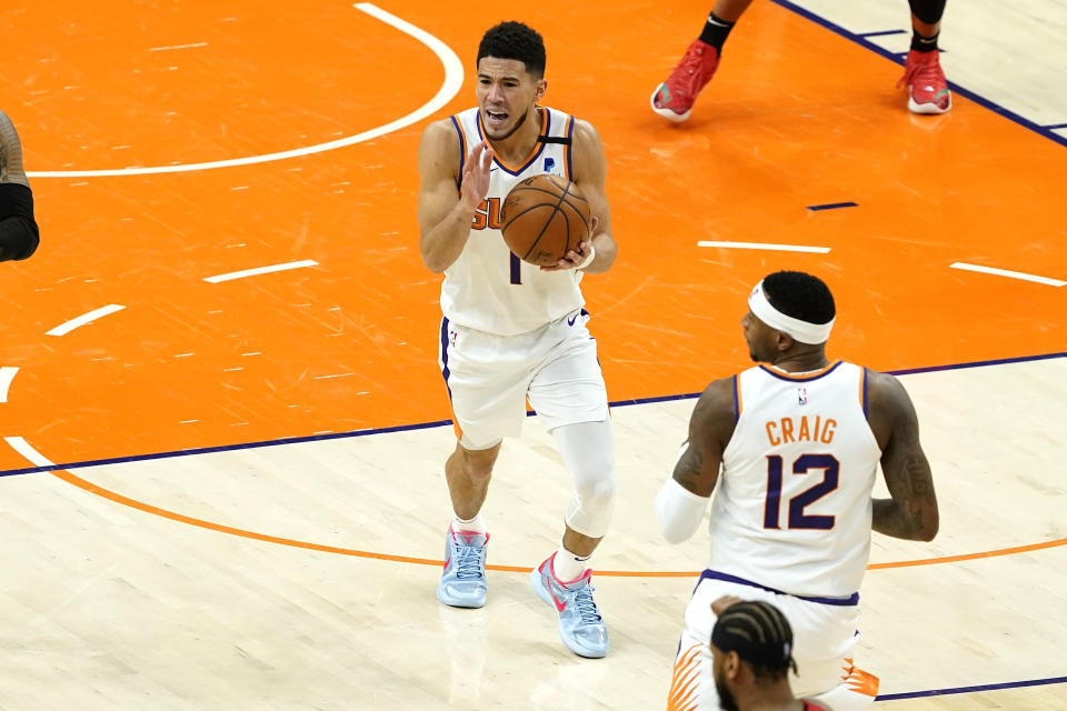 Phoenix Suns guard Devin Booker (1) reacts after turning the ball over against the Portland Trail Blazers during the second half of an NBA basketball game, Thursday, May 13, 2021, in Phoenix. (AP Photo/Matt York)