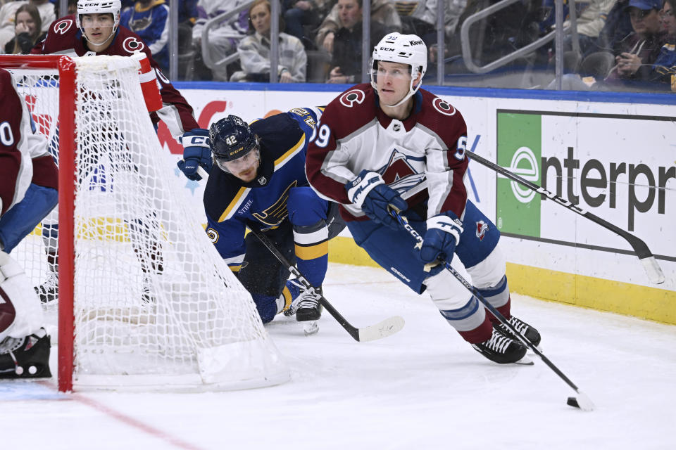 Colorado Avalanche's Ben Meyers (59) works the puck against St. Louis Blues' Kasperi Kapanen (42) during the second period of an NHL hockey game Wednesday, Dec. 29, 2023, in St. Louis. (AP Photo/Michael Thomas)