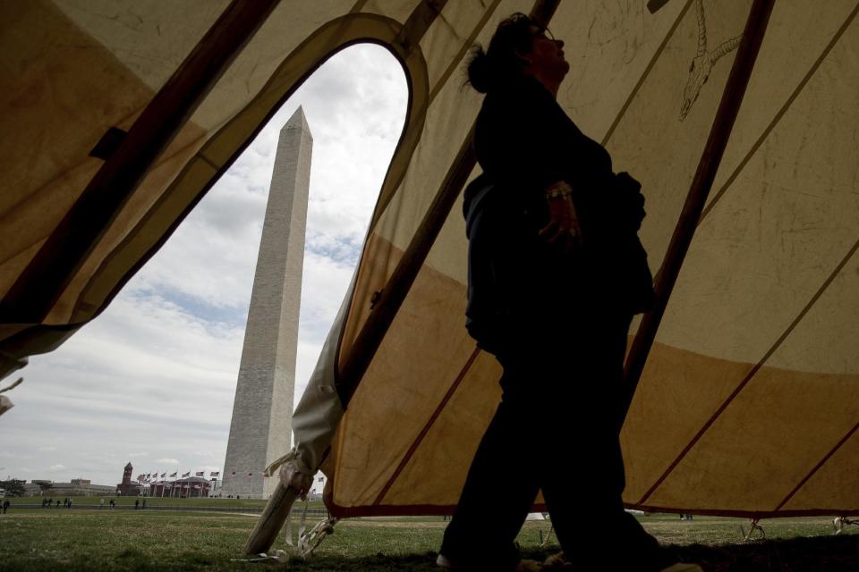 Patty Aitchison of Detroit walks into a teepee to speak with a group protesting the Dakota Access oil pipeline on the National Mall near the Washington Monument in Washington, Tuesday, March 7, 2017. A federal judge declined to temporarily stop construction of the final section of the disputed Dakota Access oil pipeline, clearing the way for oil to flow as soon as next week. (AP Photo/Andrew Harnik)