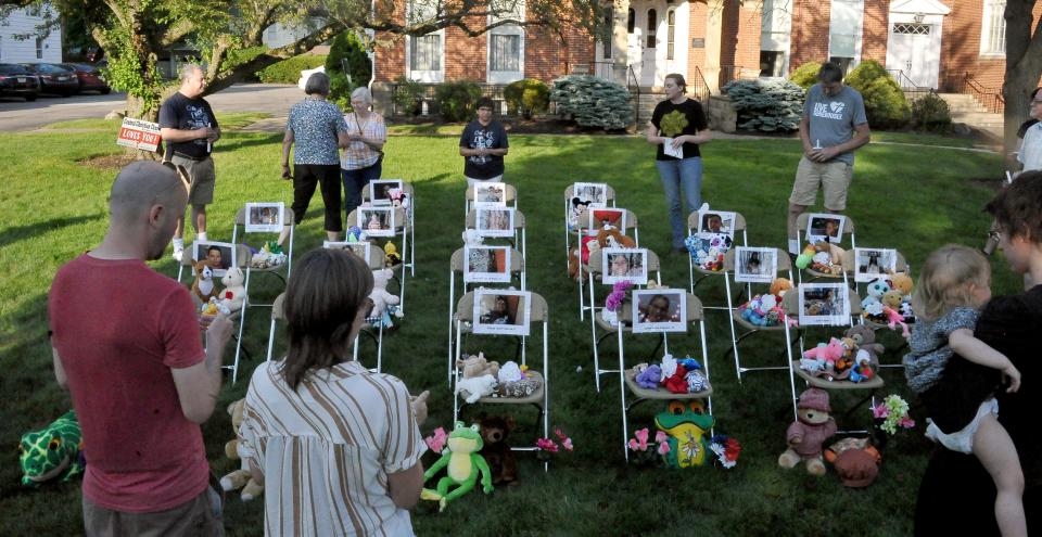 People circle 21 chairs at a Tuesday vigil in Wooster for the Uvalde school shooting victims.