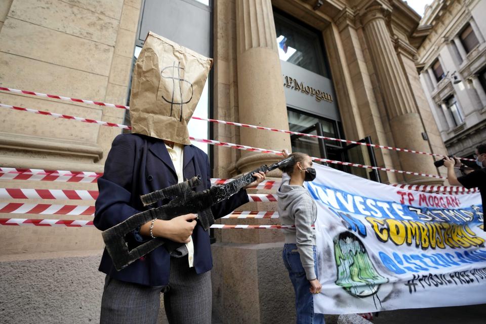 Climate activists stage a protest outside the J.P. Morgan bank headquarters in Milan, Italy, Friday, Oct. 22, 2021. (AP Photo/Luca Bruno)