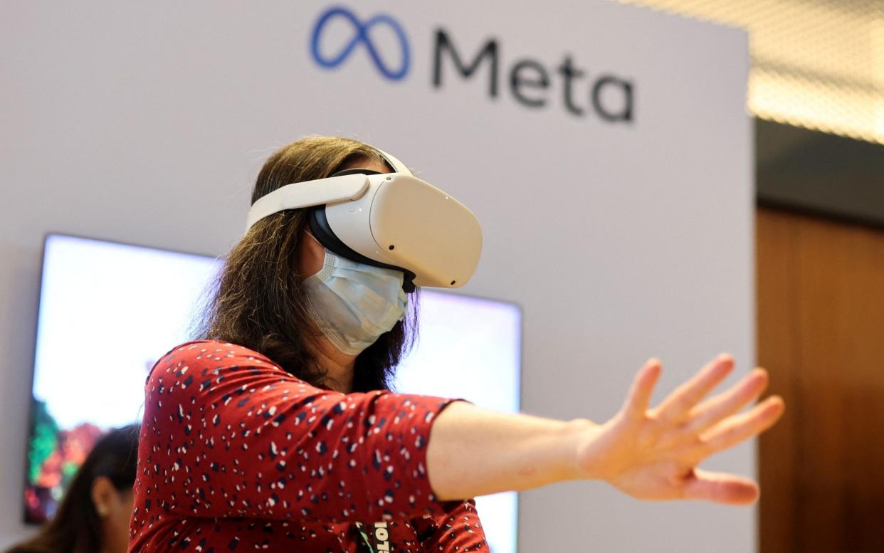 A person uses virtual reality headset at Meta stand