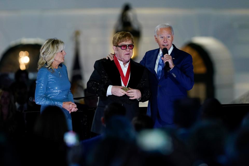 President Joe Biden speaks on the South Lawn of the White House in Washington, Friday, Sept. 23, 2022, after presenting Elton John with the National Humanities Medal, as first lady Jill Biden listens.