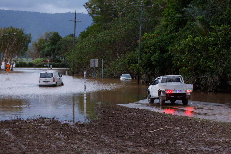 A man in a car attempts to cross a flooded road in Cairns this month. Source: AAP