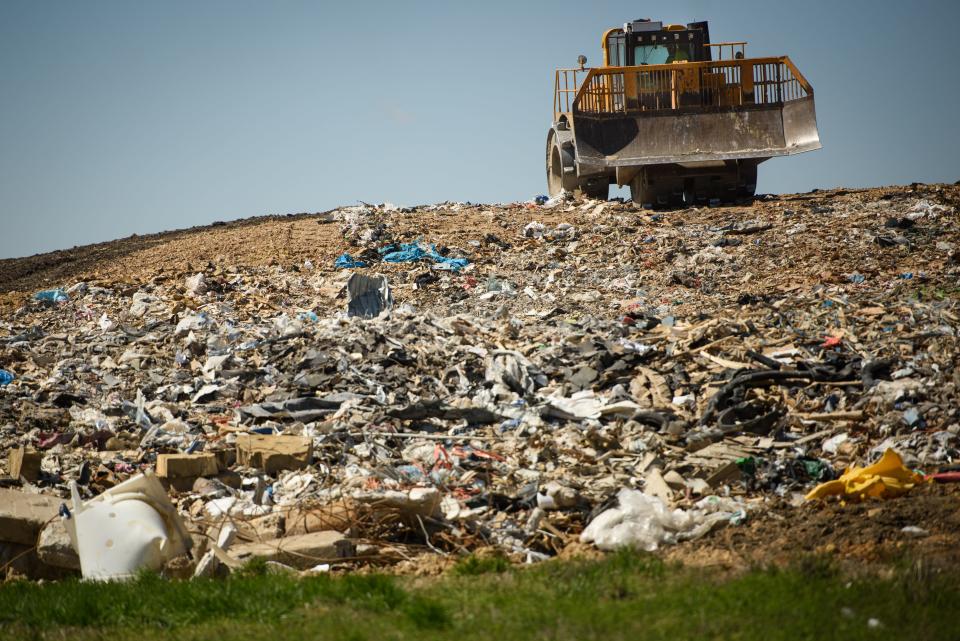 A tractor moves and compacts waste at the construction and demo site at the Ann Street Landfill on Tuesday, March 14, 2023.
