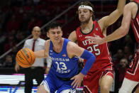 BYU guard Alex Barcello (13) drives around Utah guard Rollie Worster (25) during the first half of an NCAA college basketball game Saturday, Nov. 27, 2021, in Salt Lake City. (AP Photo/Rick Bowmer)