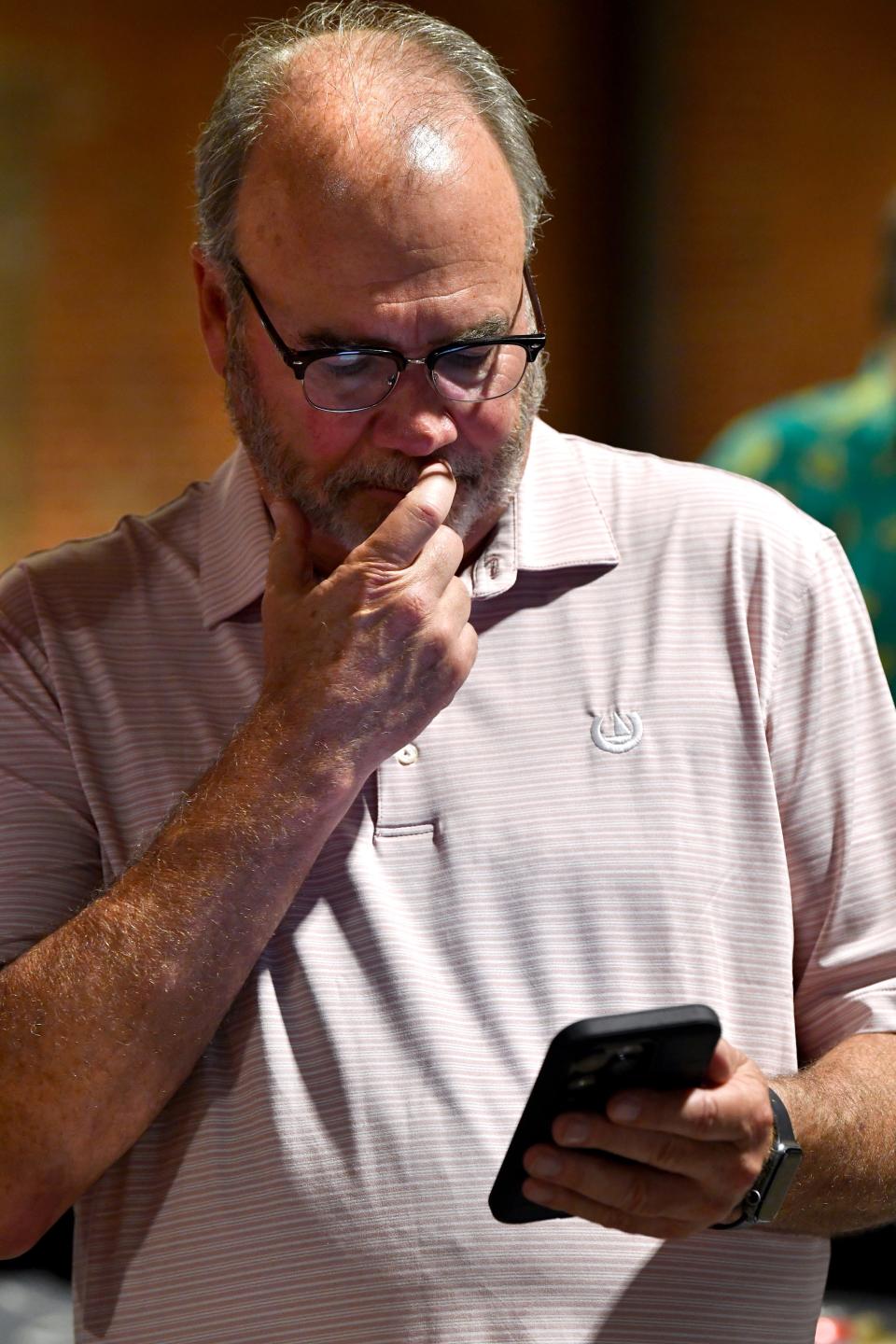 Scott Beard checks election results on his phone during the watch party for his Abilene City Council Place 4 race Saturday.