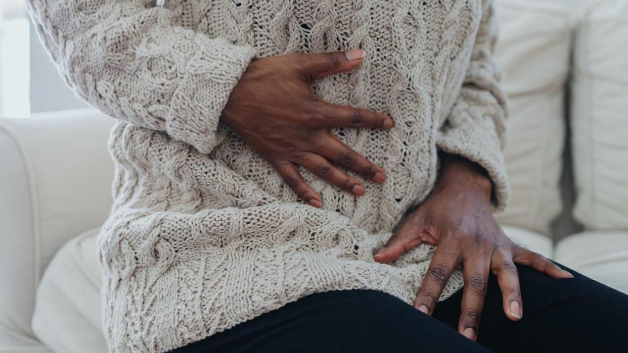 woman holding abdomen in pain