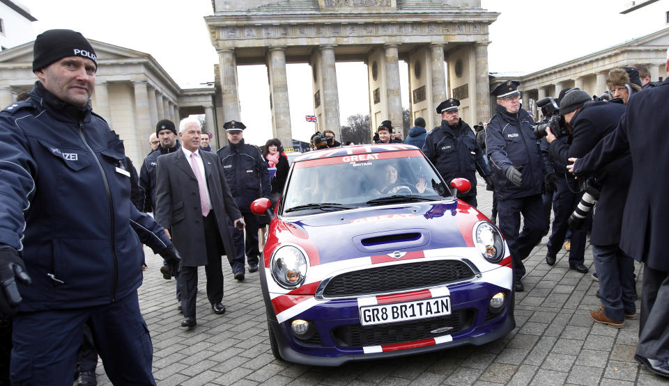 Members of the British royal family, Princess Beatrice of York, left, and Princess Eugenie of York, right, are protected by the police as they drive a car during a promotion event for the Great Britain MINI Tour 2013 at the Brandenburg Gate in Berlin, Germany, Thursday,Jan.17, 2013. It was meant to be a Mini adventure that nearly became a major embarrassment. Two British royals on a mission to promote their country broke German road rules by running a red light near Berlin's iconic Brandenburg Gate. With photographers and police in tow, Princess Eugenie and her older sister Princess Beatrice then took a swift right into the safety of the British embassy compound. At least the 22 and 24-year-old sisters didn't have to decide which side of the road to drive on. The entire 500-meter (550-yard) staged tour was along one-way streets (AP Photo/Michael Sohn)