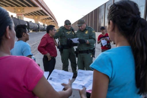 US Customs and Border Protection agents in May 2019 check documents in El Paso, Texas, from a small group of migrants who crossed from Mexico