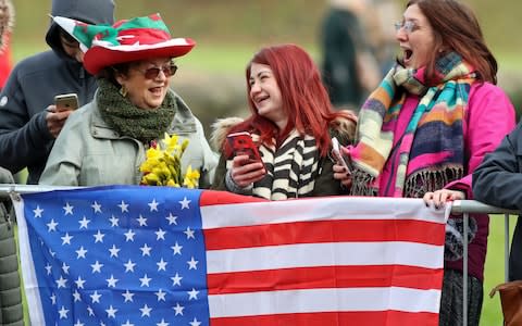 Welsh hat, American flag: Excited members of the public await the couple's arrival - Credit: Andrew Matthews /PA